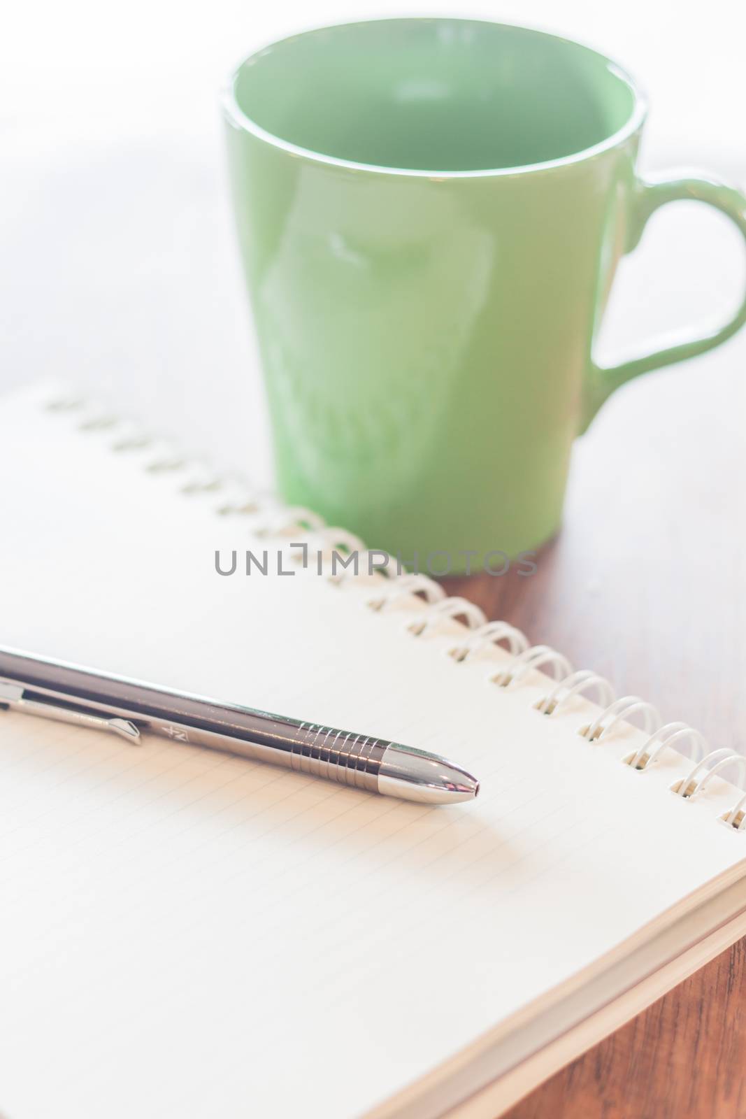 Pen and notebook with green mug by punsayaporn