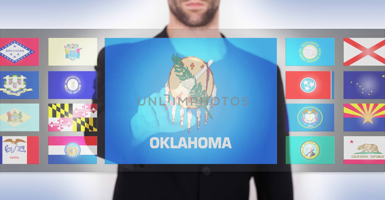 Hand pushing on a touch screen interface, choosing a state, Oklahoma