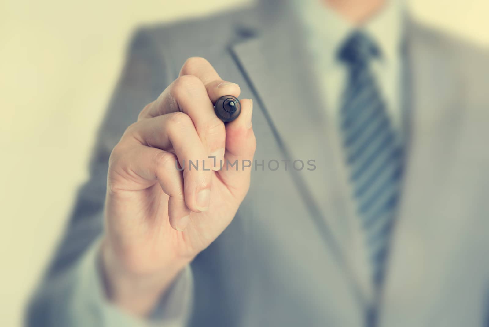 Close up businessman hand writing with marker on blank transparent screen, in vintage toned.