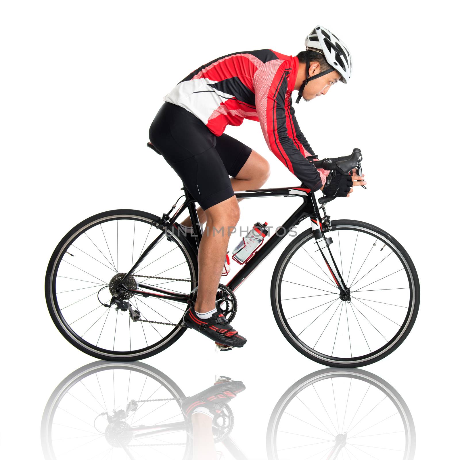 Asian male cyclist riding road bicycle, side view isolated on white background.