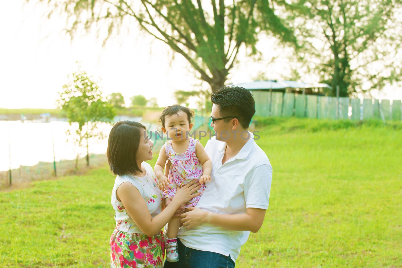 Portrait Of Asian Chinese Family Relaxing In Park Together