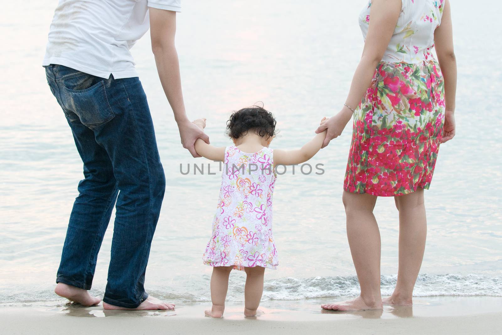 Asian family outdoor on sand beach, vacation during summer, natural sunset sunlight.