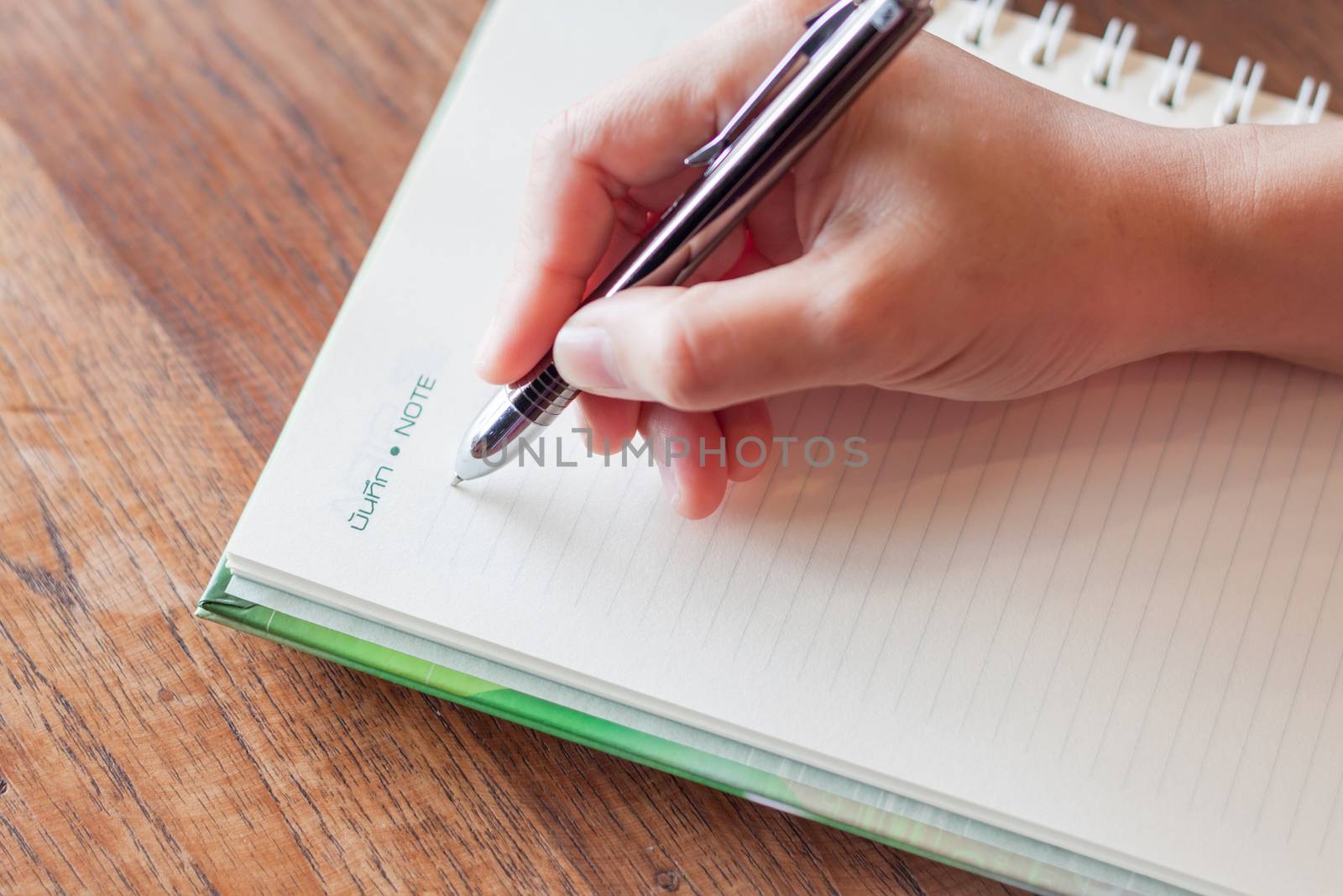 Writing important note on spiral notebook, stock photo