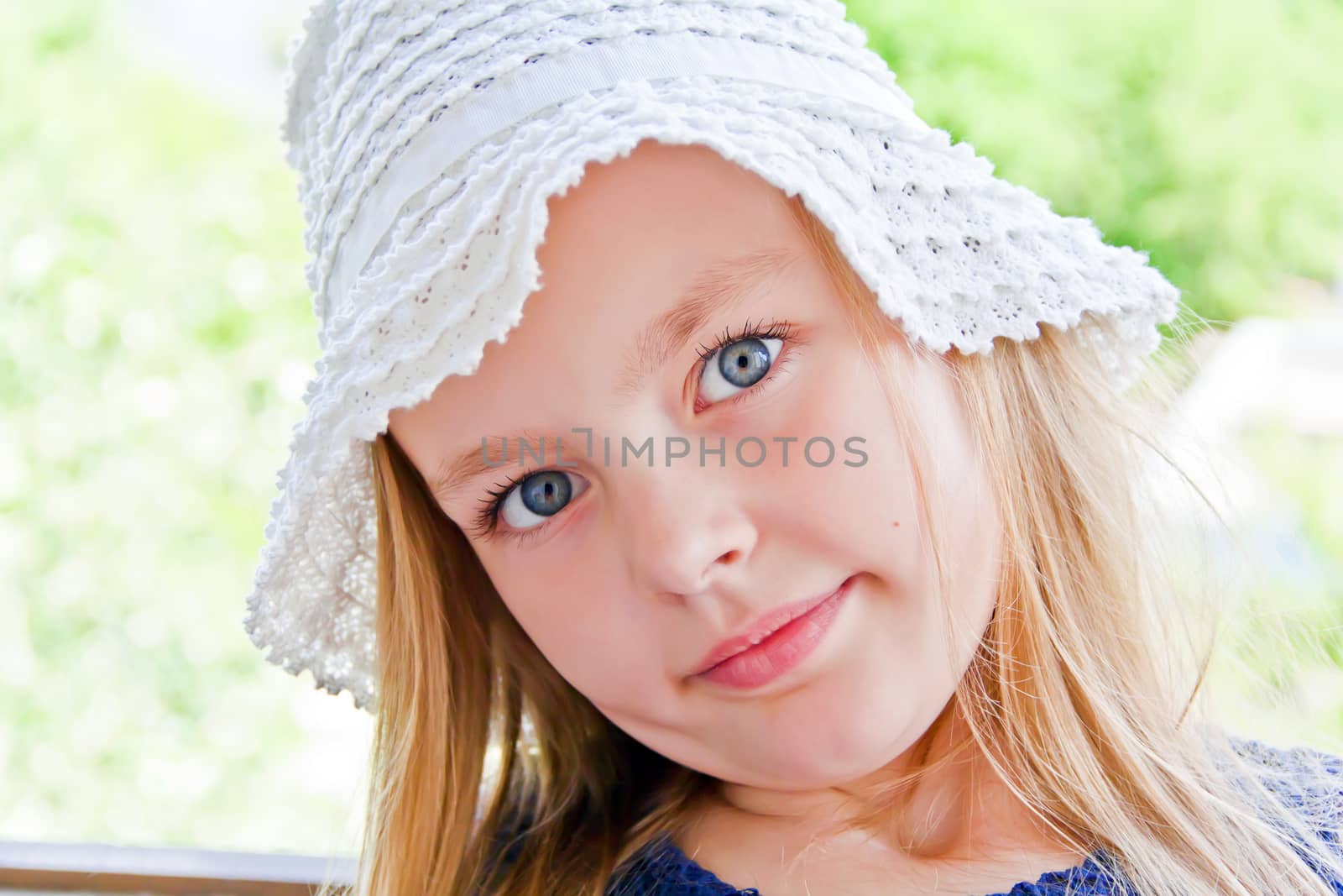 Cute girl with big blue eyes in white hat