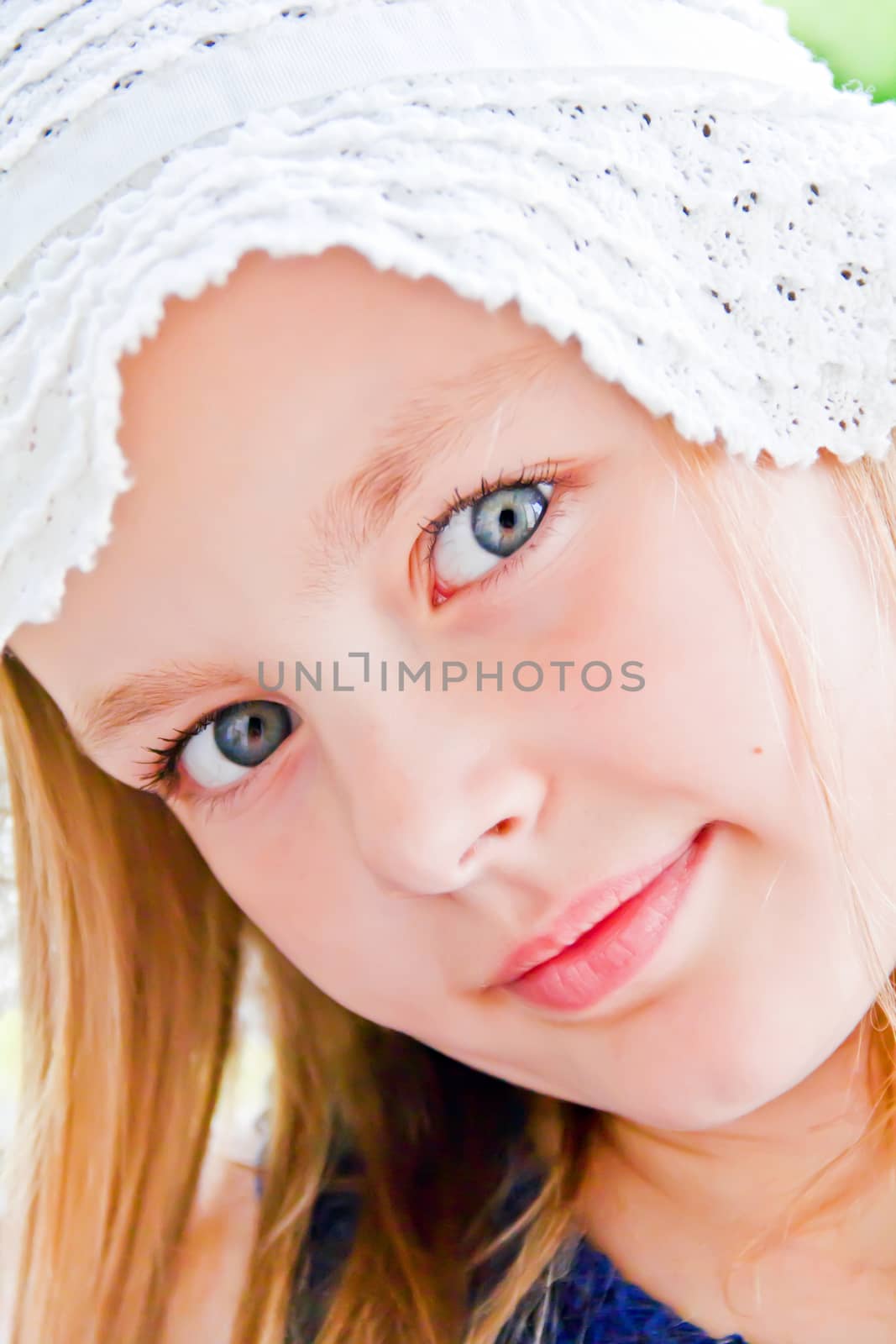 Cute girl with big blue eyes in white hat