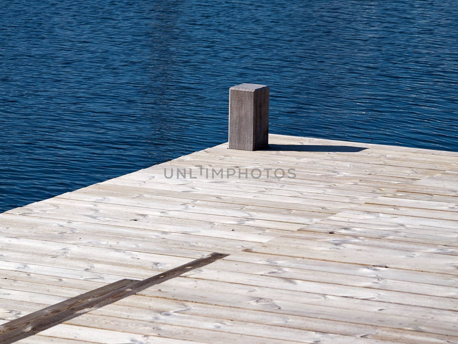 Small beautiful seaside wooden jetty dock pier deck by the ocean 