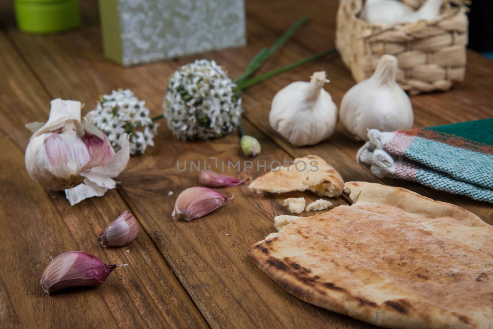 Fresh garlic bulb and flowers and naan bread on kitchen table