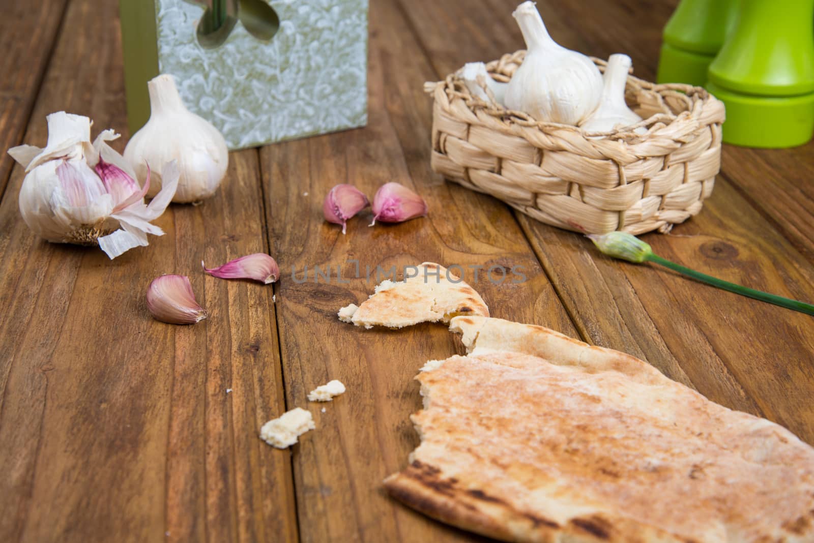 Fresh garlic bulb and flowers and naan bread on kitchen table