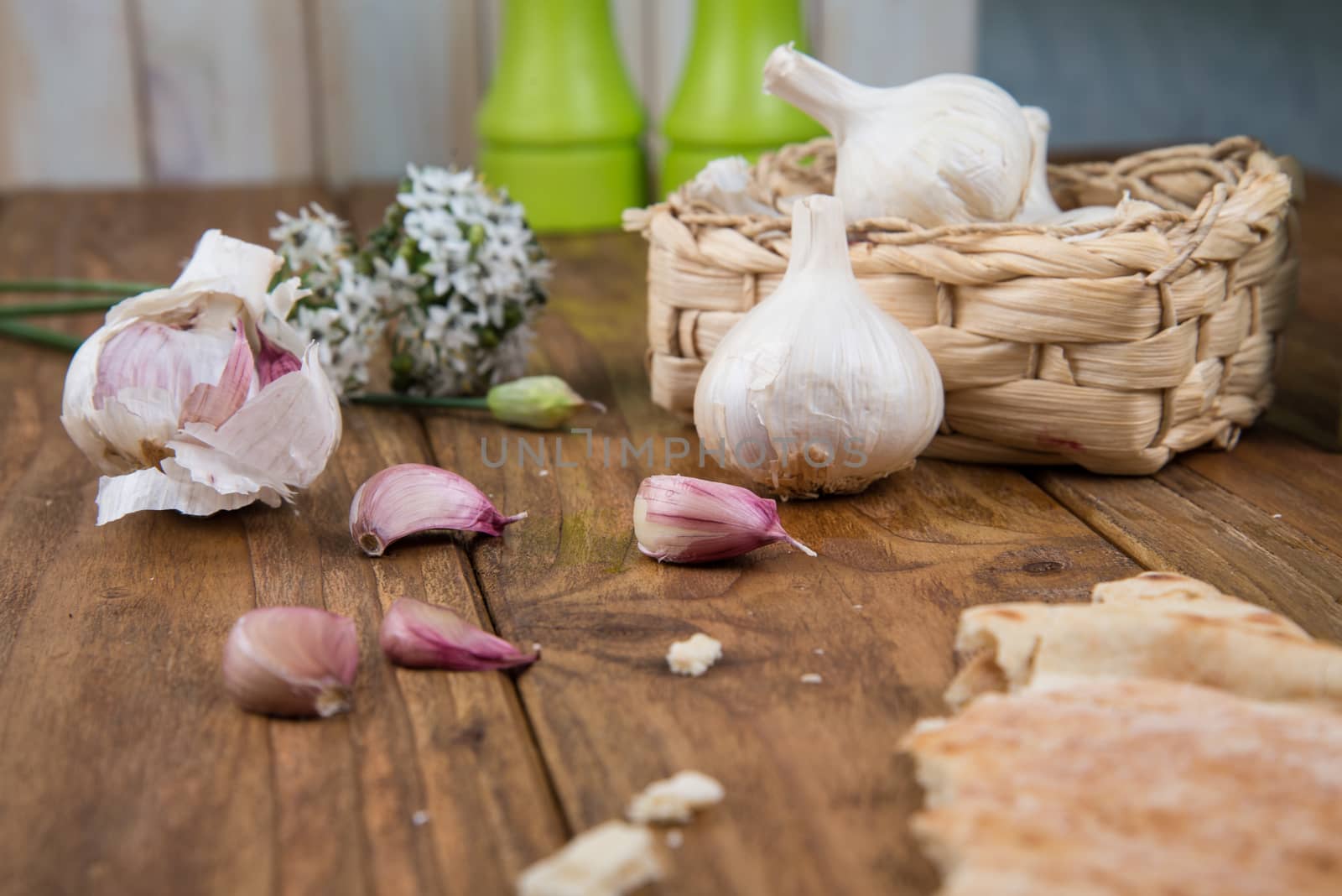 Fresh garlic bulb and flowers and naan bread on kitchen table