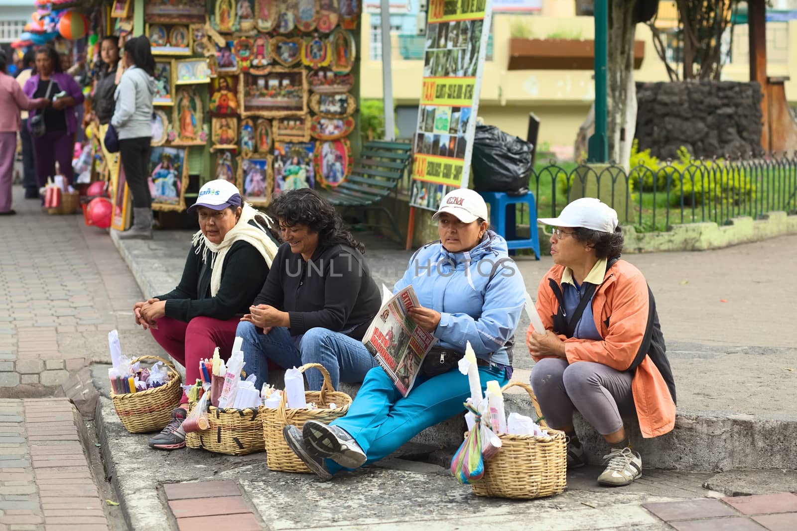BANOS, ECUADOR - FEBRUARY 22, 2014: Unidentified women selling candles outside the cathedral on February 22, 2014 in Banos, Ecuador. 