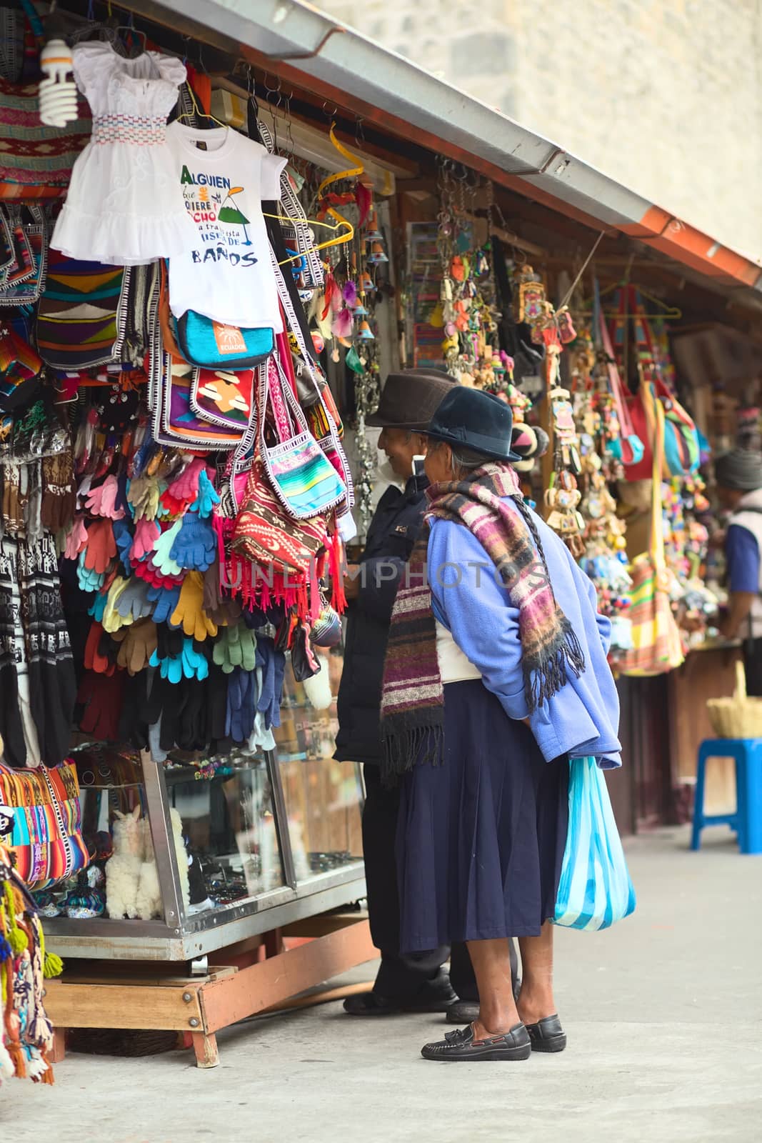 BANOS, ECUADOR - FEBRUARY 22, 2014: Unidentified elderly people standing at a handicraft stand in the Pasaje Artesanal (Artisan Passage) on February 22, 2014 in Banos, Ecuador. 