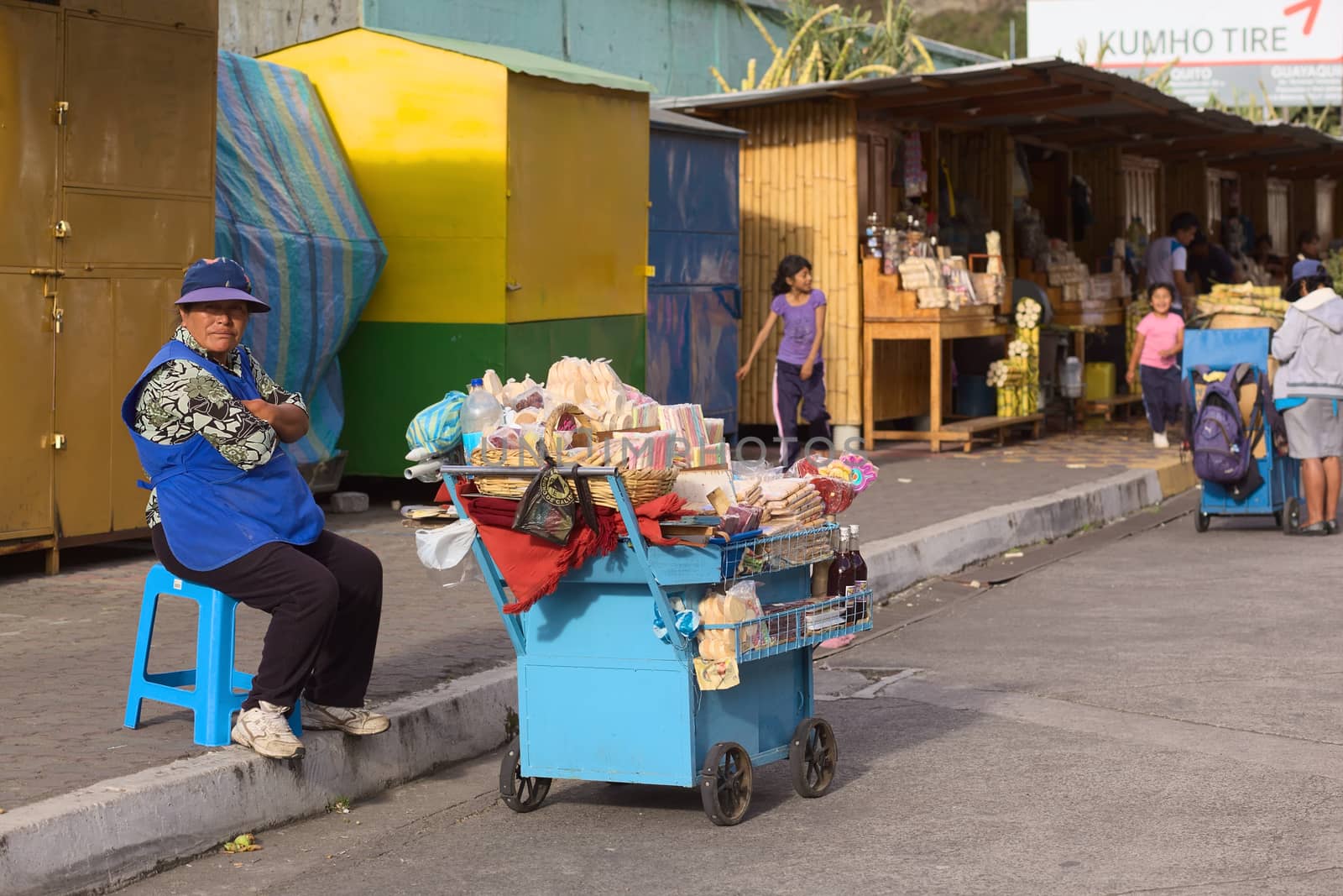 BANOS, ECUADOR - FEBRUARY 26, 2014: Unidentified woman selling sweets from a cart on Luis A. Martinez street on February 26, 2014 in Banos, Ecuador. She is selling also melcocha, a traditional taffy from Banos made of sugarcane. 