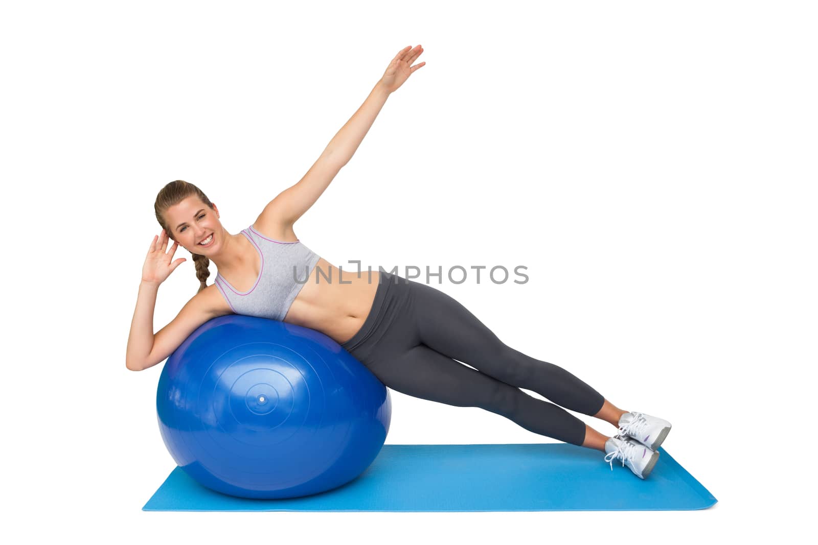 Portrait of a fit young woman stretching on fitness ball over white background