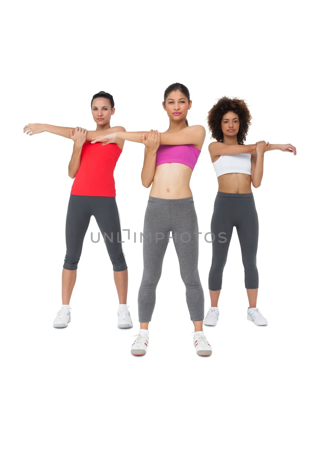 Three sporty young women stretching hands by Wavebreakmedia