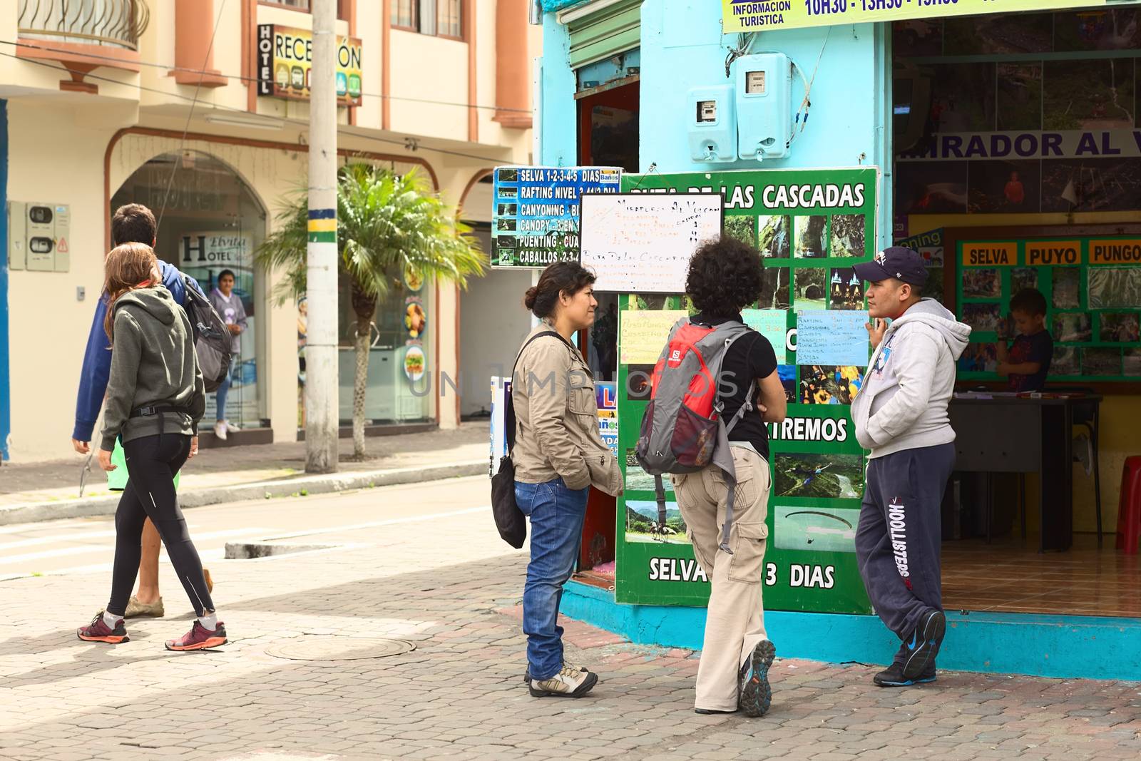 BANOS, ECUADOR - FEBRUARY 25, 2014: Unidentified people in front of the tour operator Tungurahua Explorer on the corner of the streets 16 de Diciembre and Vicente Rocafuerte on February 25, 2014 in Banos, Ecuador. Banos is a small touristy town, mainly visited for its numerous outdoor activities and adventure tours, which are being offered by many tour operators all over town.