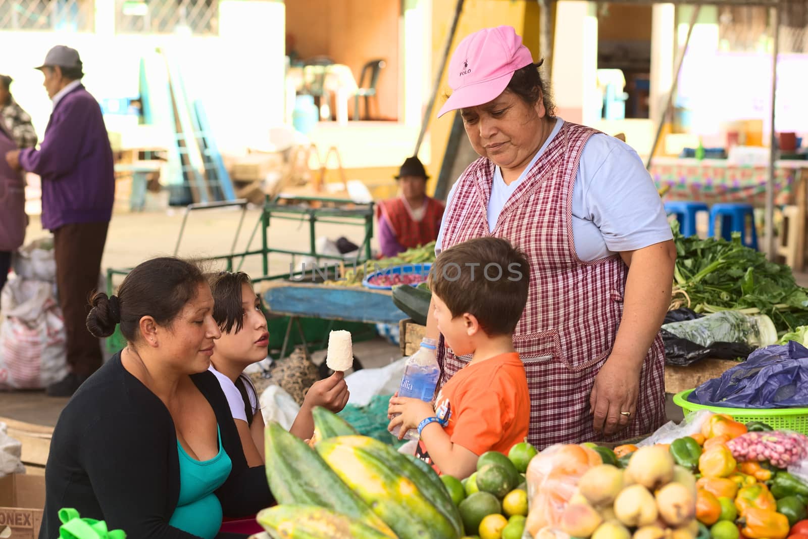 BANOS, ECUADOR - FEBRUARY 26, 2014: Unidentified people on the market on Plaza 5 de Junio on February 26, 2014 in Banos, Ecuador. On the market, which is held every Wednesday, Friday and Sunday, mainly fruits and vegetables are being offered, with a few stands of dairy and meat products. 