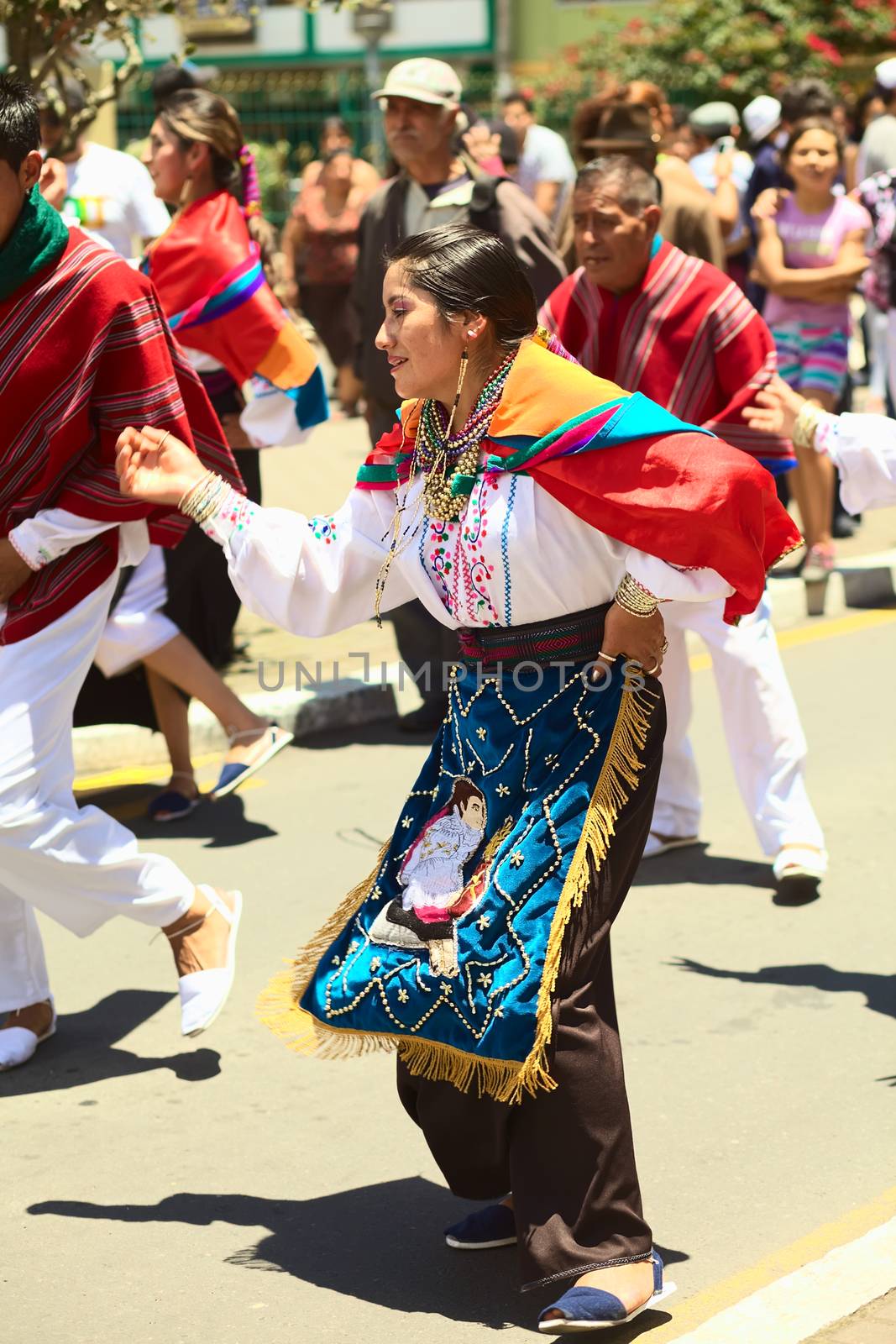 BANOS, ECUADOR - MARCH 2, 2014: Unidentified people dressed in traditional clothes and dancing to music on the carnival parade on Maldonado street on March 2, 2014 in Banos, Ecuador.