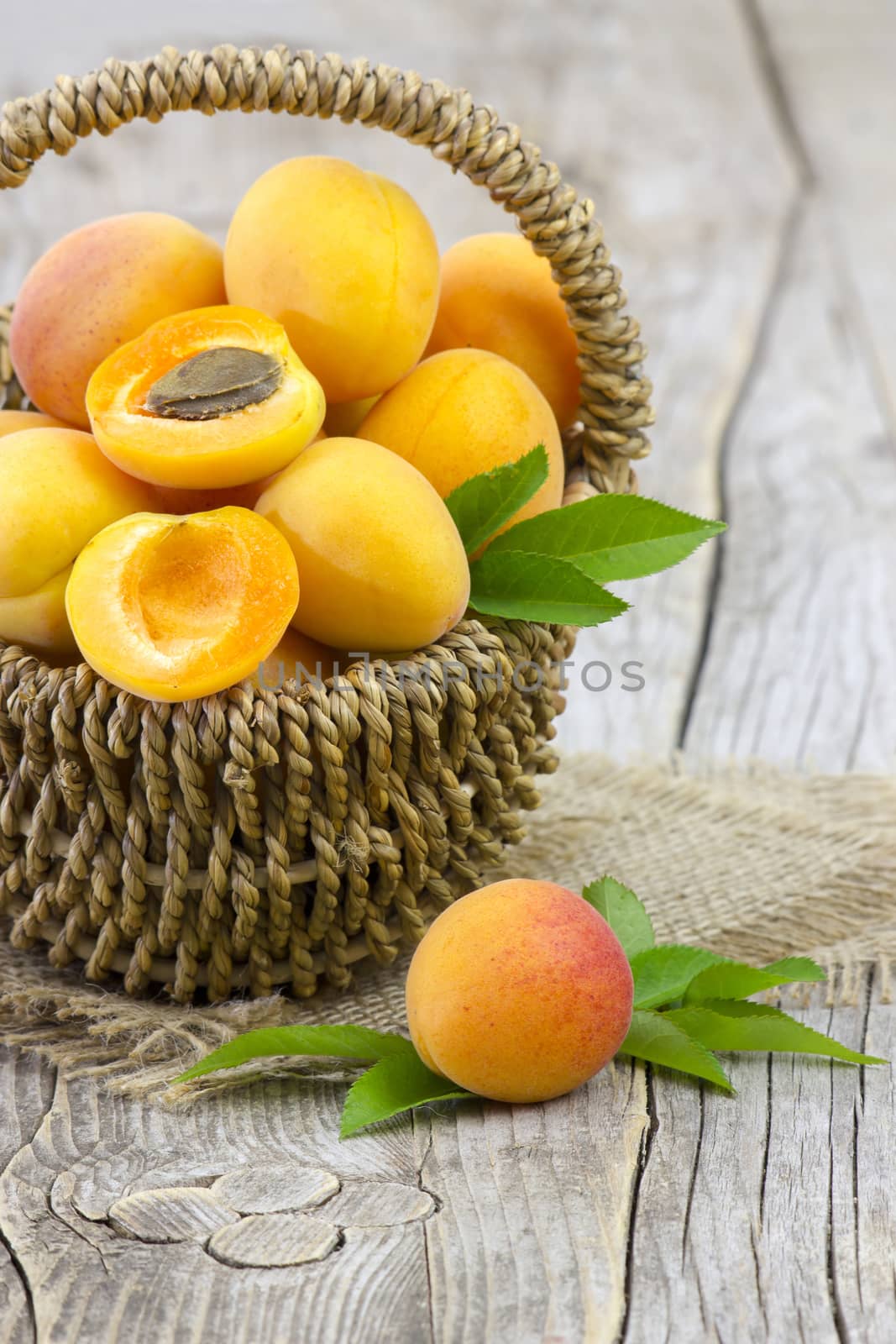 fresh apricots in a basket on wooden background