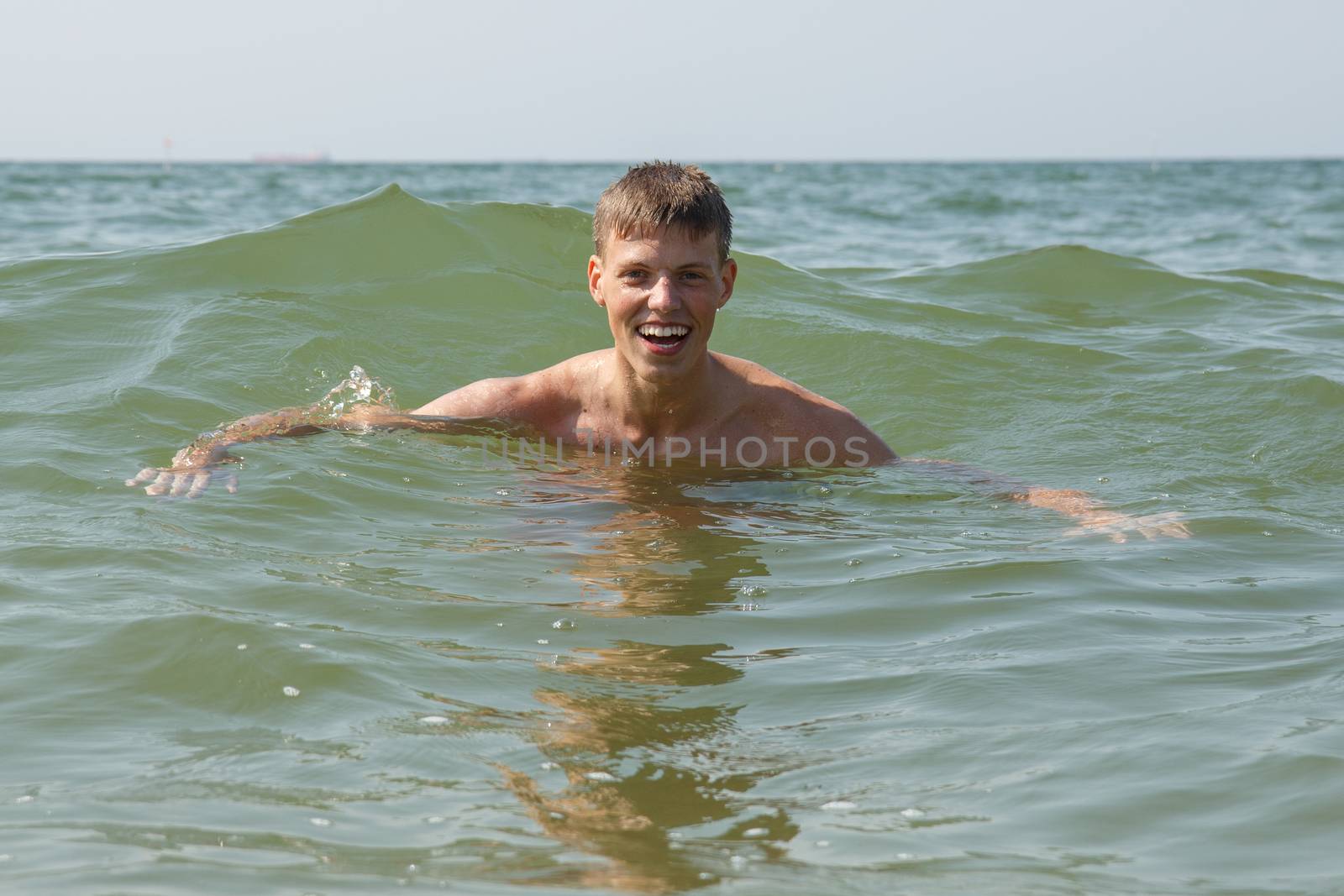 A swimming teen male person in the ocean