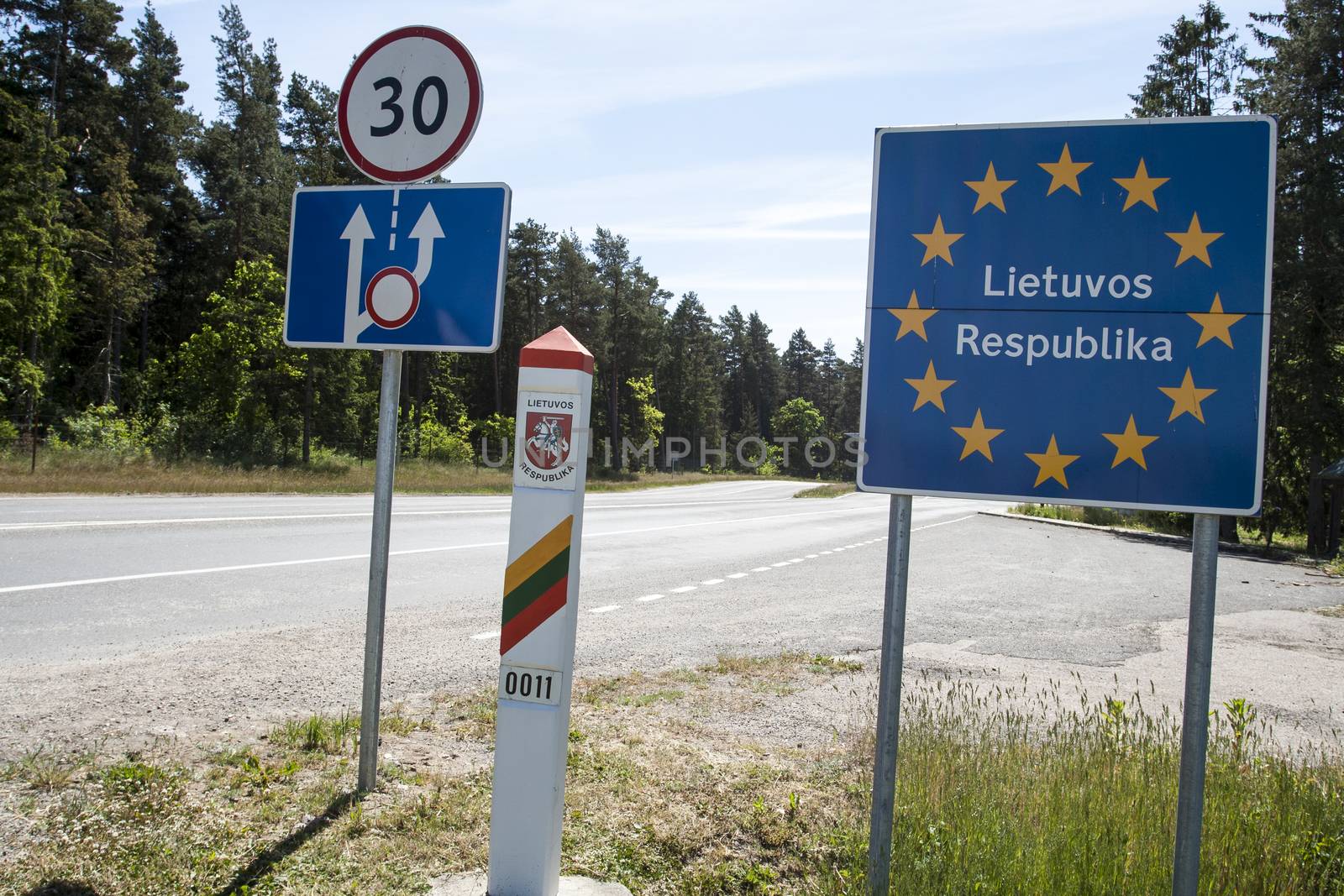 Lithuania country border sign between Latvia and Lithuania with coat of arms and flag.