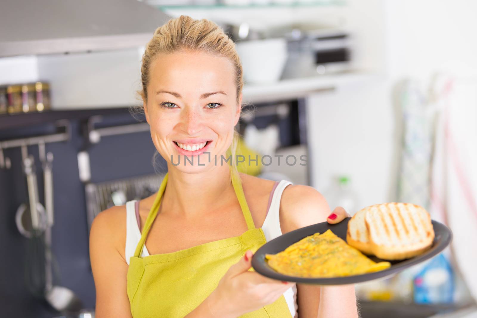 Young Woman Cooking. Healthy Mediterranean Breakfast - Home Made Egg Omlete Stuffed with Dried Tomatoes in Olive Oil and Cheese. Diet. Dieting Concept. Healthy Lifestyle. Cooking At Home.  