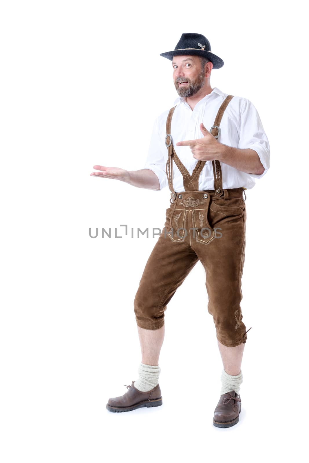 A traditional bavarian man isolated on a white background presenting something