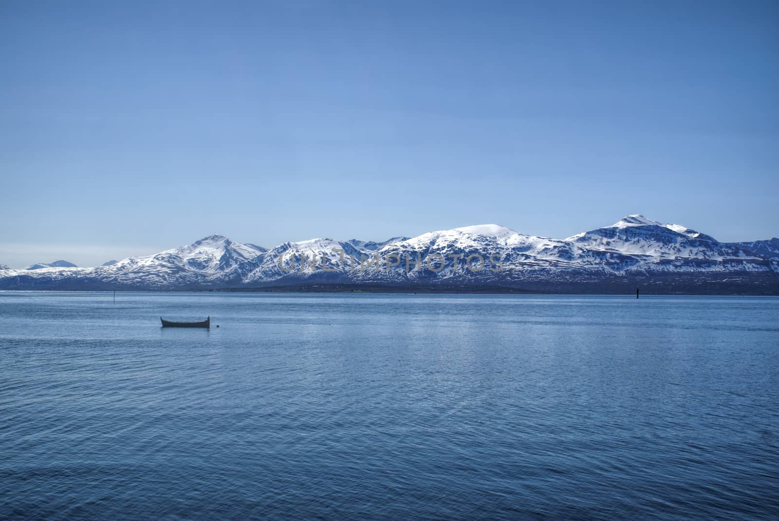 Scenic view of the mountains and a boat in a fjord in Tromso, Norway                    