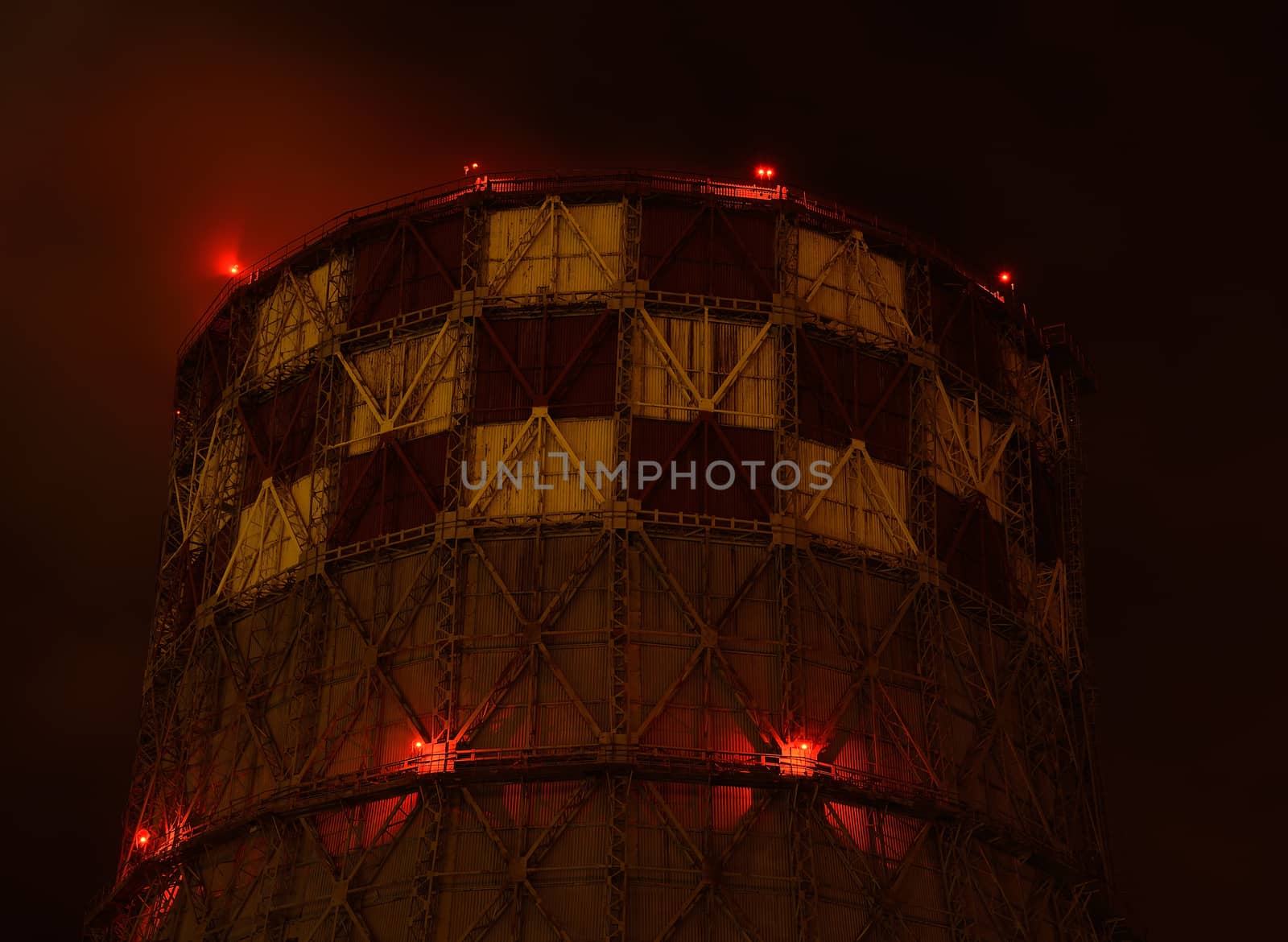 Pipe energy sector emits smoke into the atmosphere. Night view. Lights red lanterns