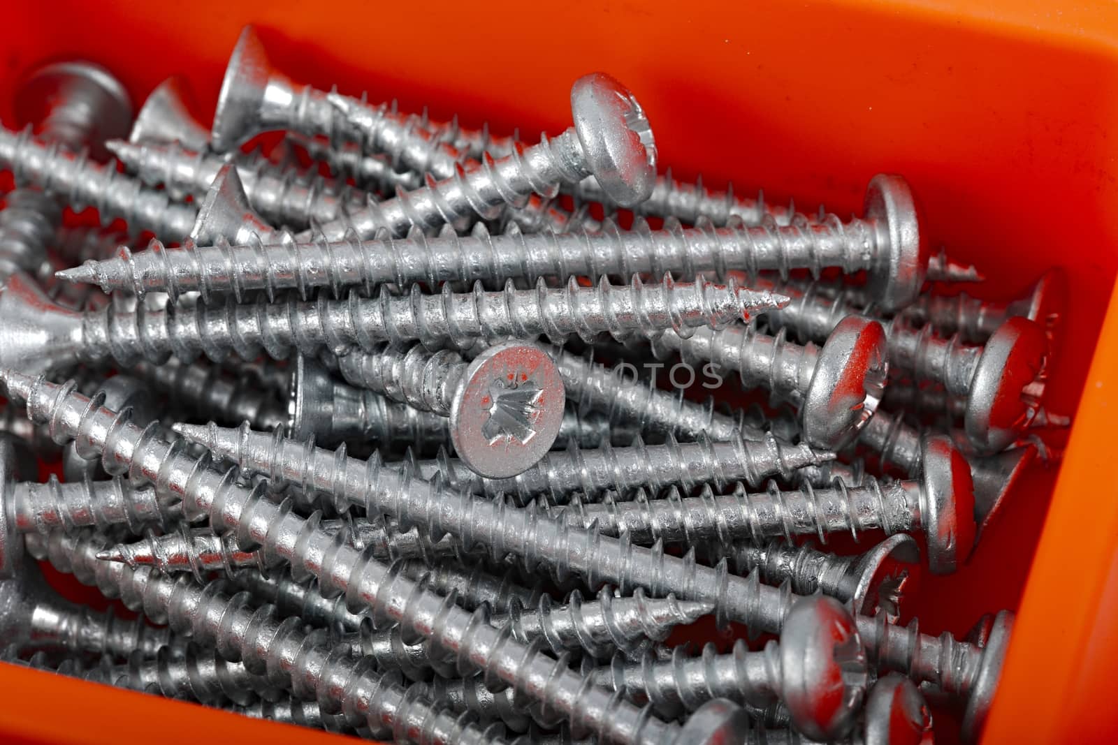 A pile of screws in a box