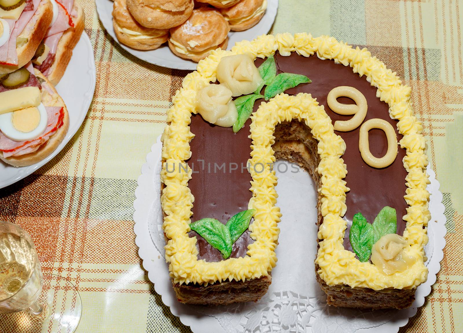 homemade birthday cake for ninety anniversary with other snacks on desk