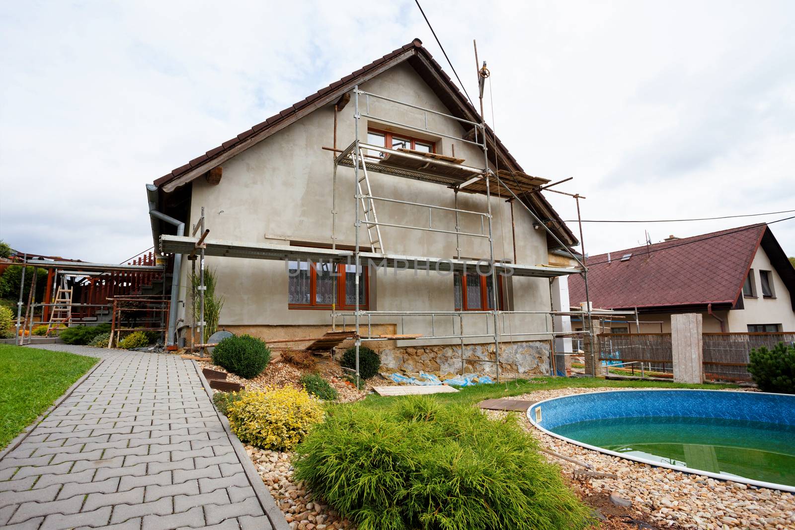 repaired rural house, fixed facade, insulation and painted to green  color witg swimming pool