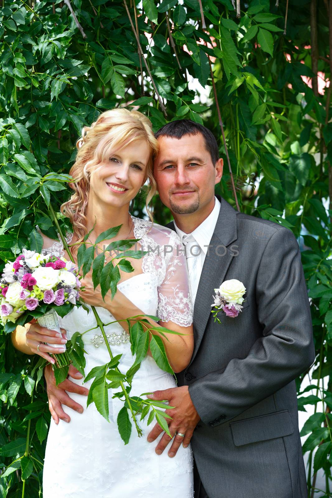 beautiful young wedding couple, blonde bride with flower and her groom