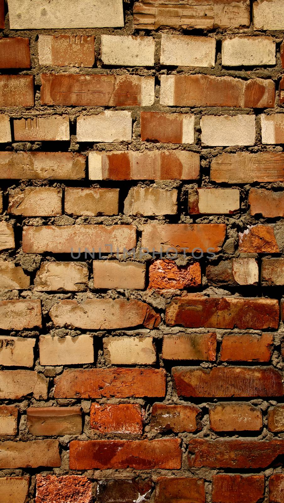 Background of Old Damaged Red Variegated Brick with Concrete Smoothing. Vertical View