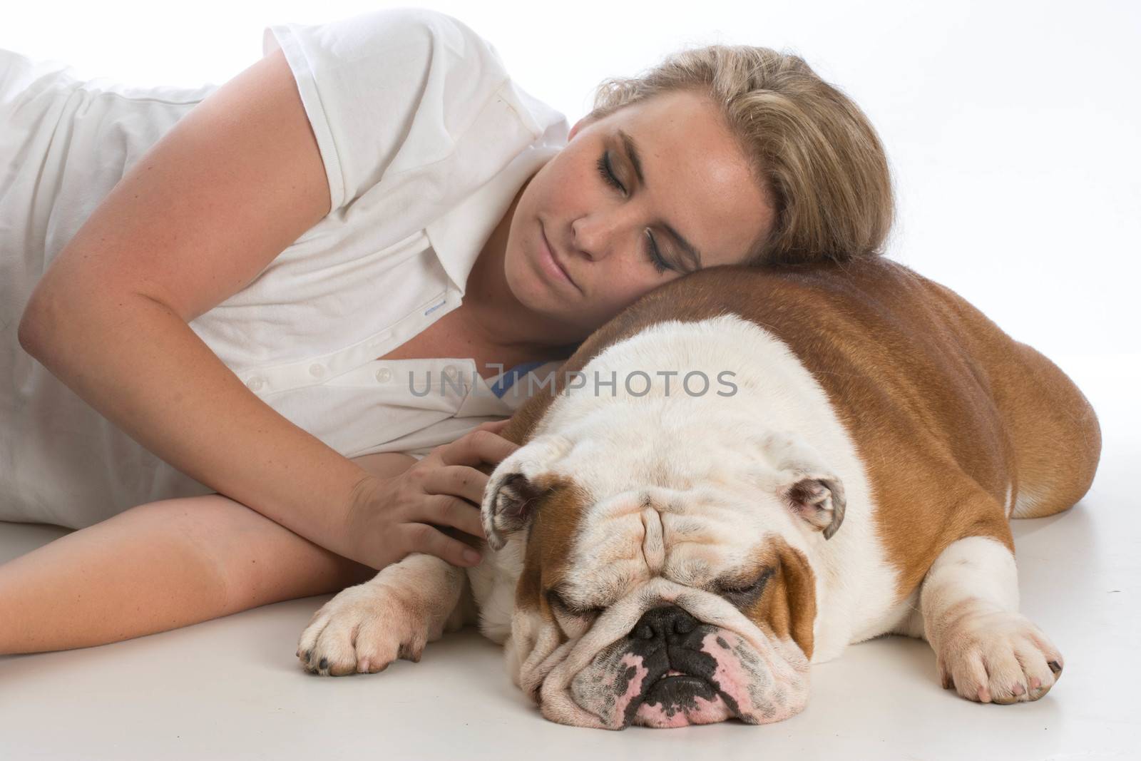 woman resting her head on her english bulldog on white background