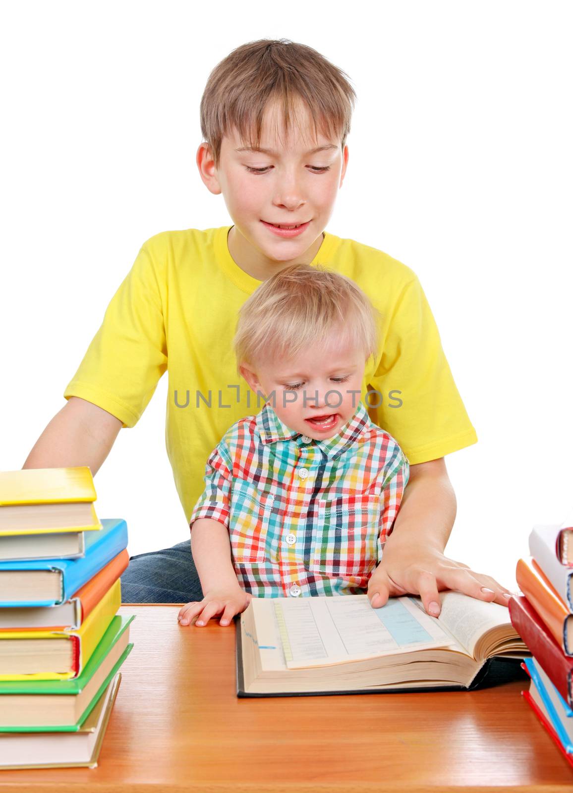 Kid and Baby Boy with the Books at the Desk Isolated on the White Background