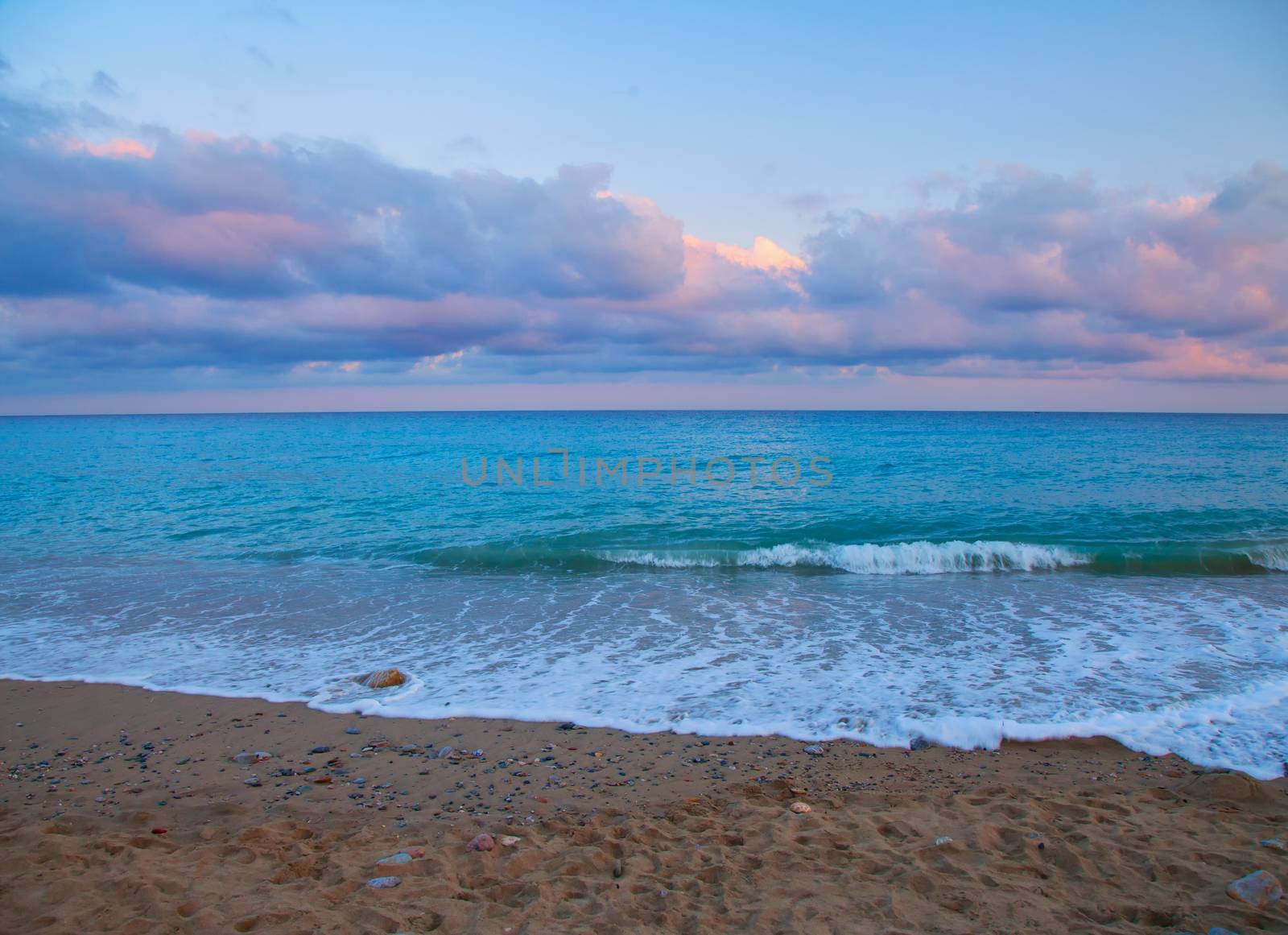 Sea coming to the beach under wonderful sunset lights