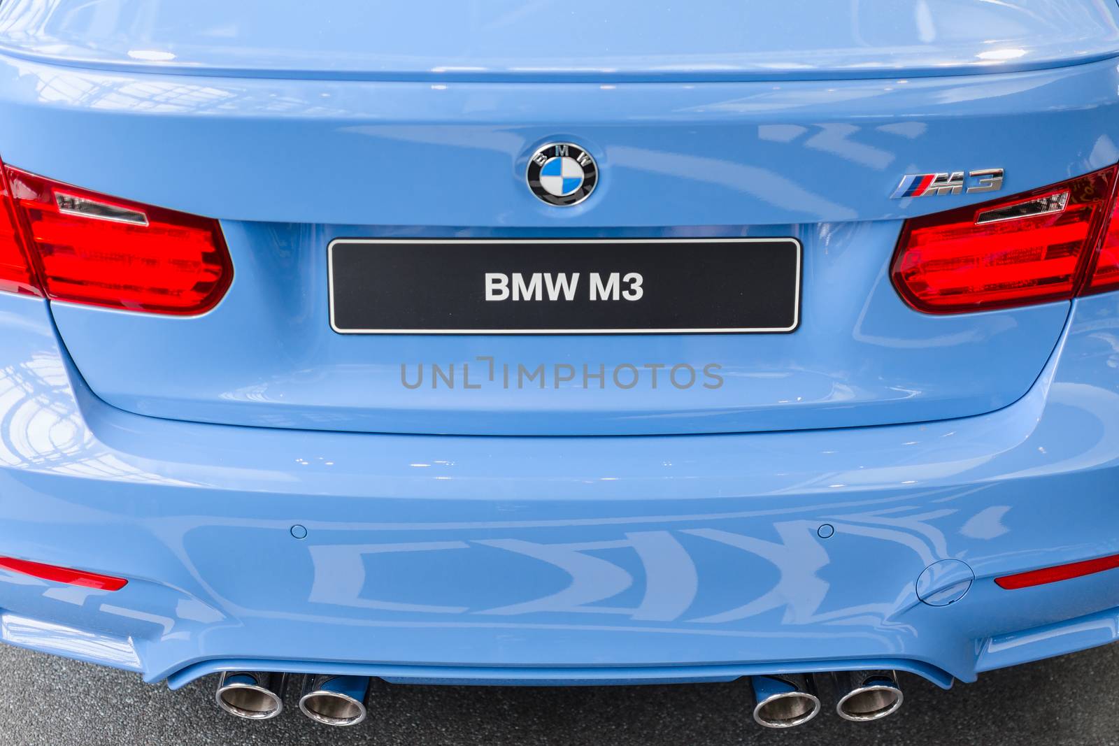 MUNICH, GERMANY - AUGUST 9, 2014: Rear view of new generation model BMW M3 - prestigious sports style car. Close-up details with chrome exhaust pipes and stop lights.