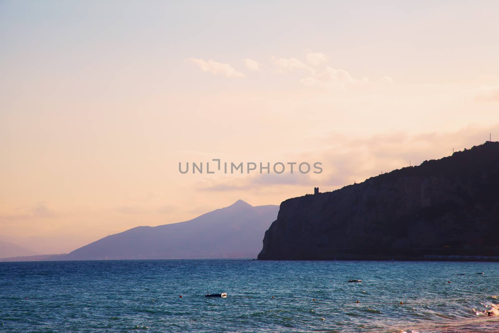 Sea, big sky and a far tower over a hill