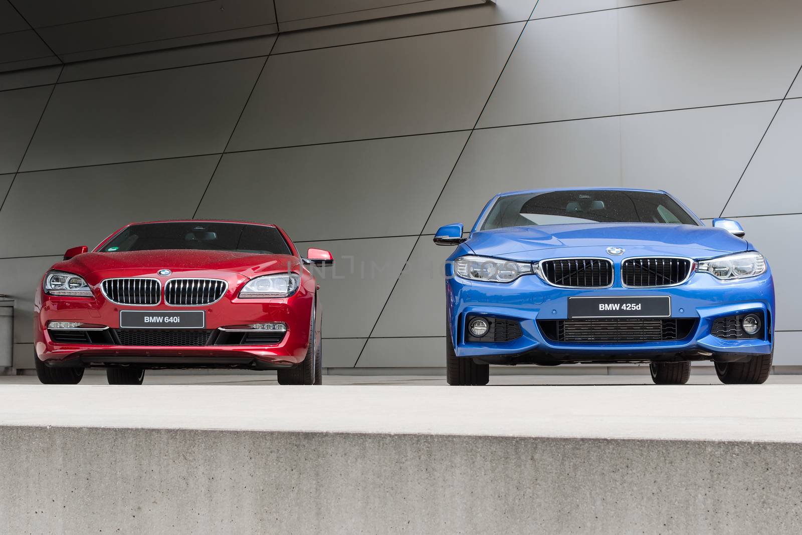 MUNICH, GERMANY - AUGUST 9, 2014: Latest generation of new model lineup BMW luxury cars. Wet after rain two 640i and 425d front view.