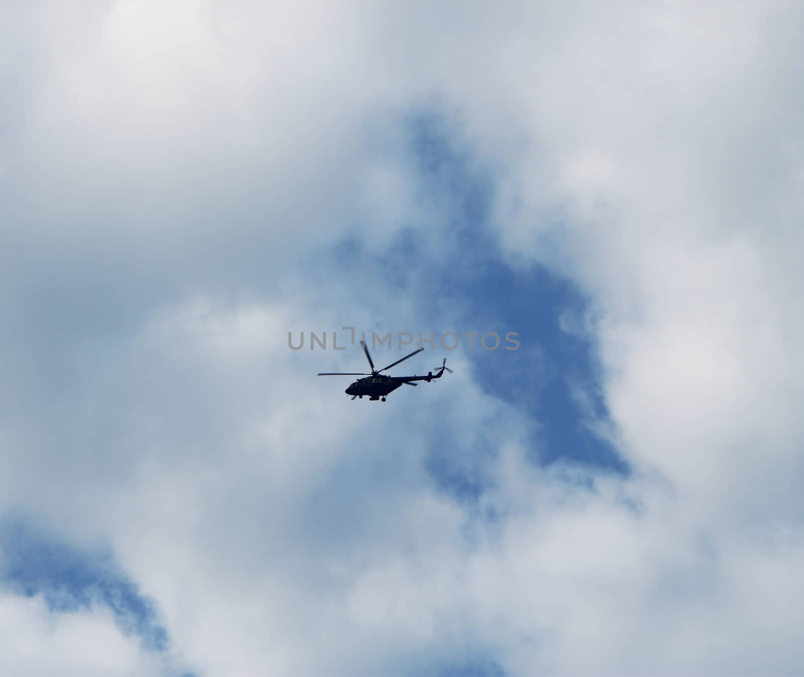 Helicopter flightning in blue sky with clouds