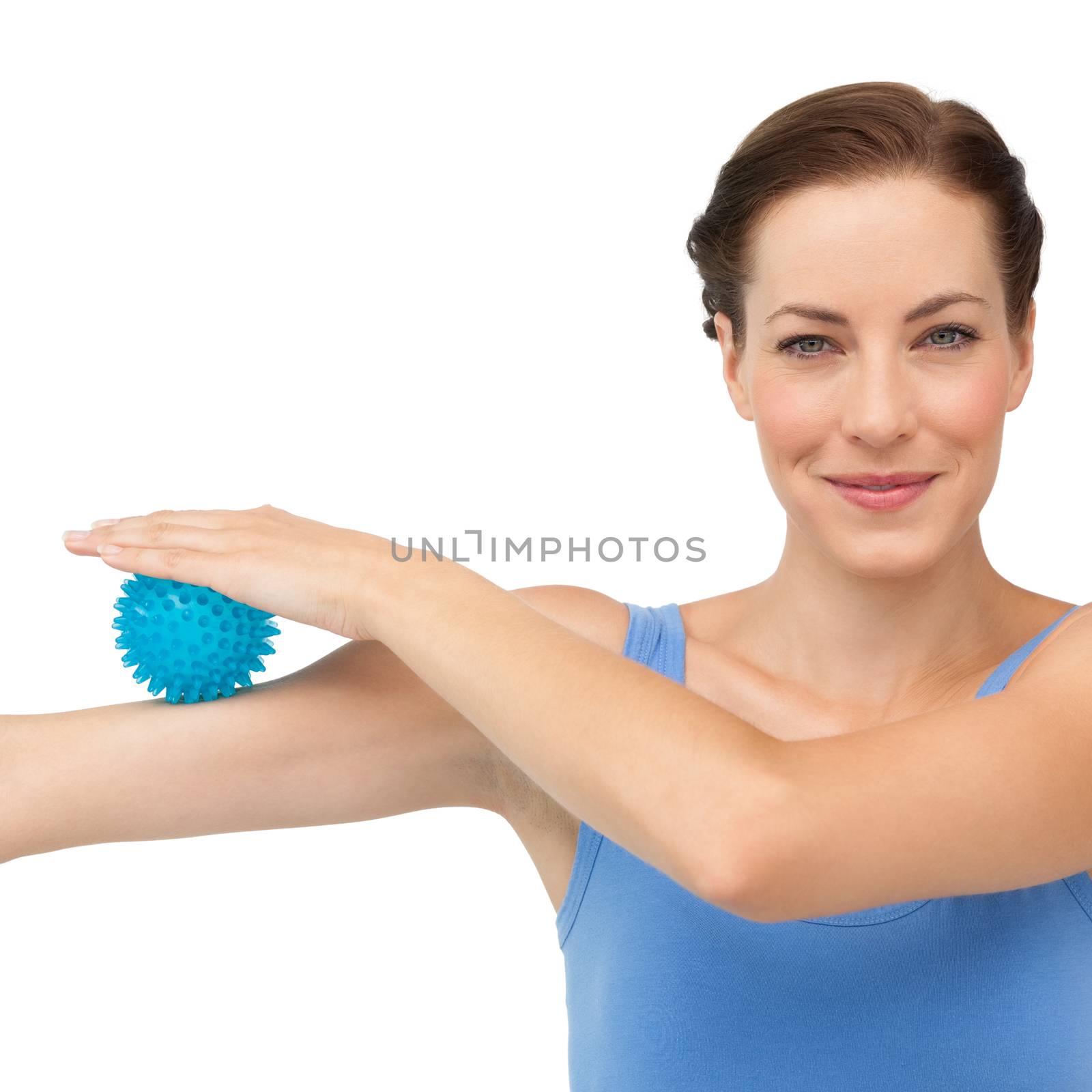 Portrait of a content young woman holding stress ball on arm over white  background