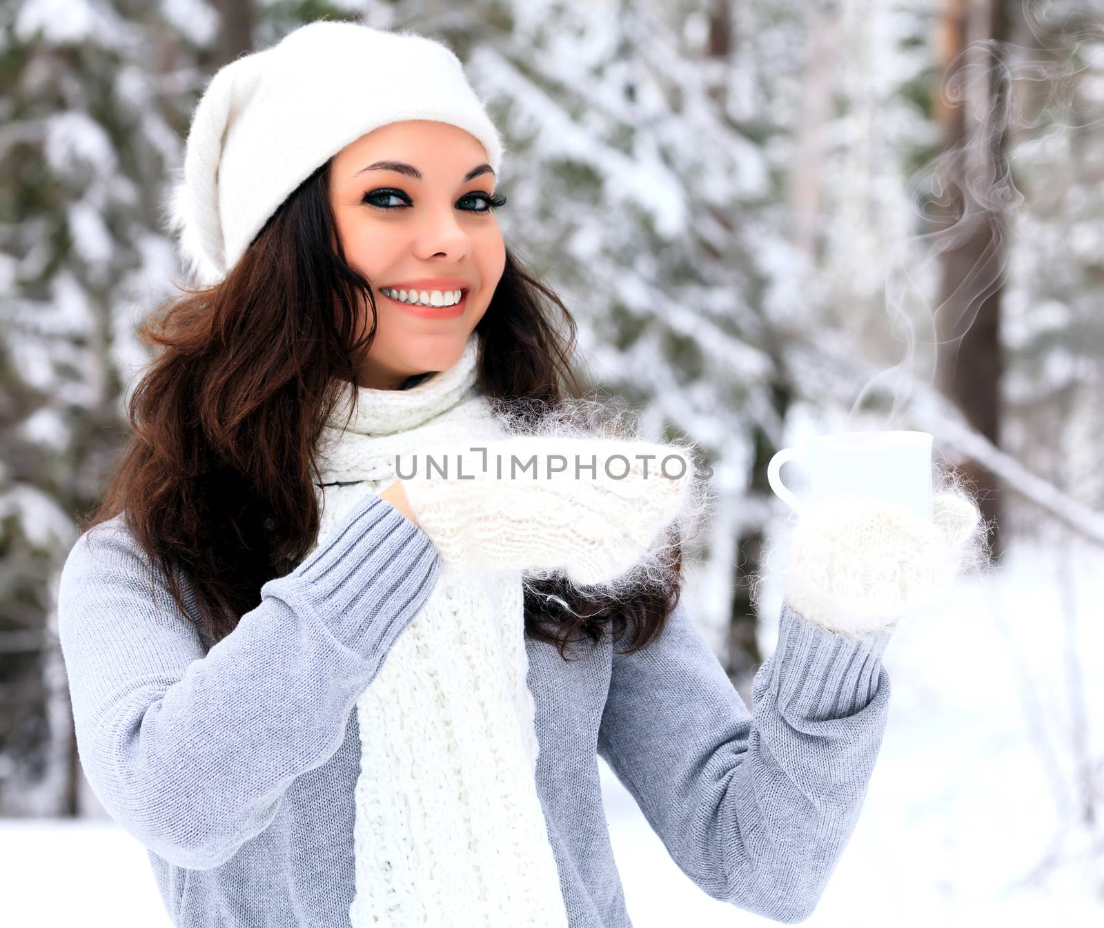 Woman with a cup of hot tea or coffee posing outdoors