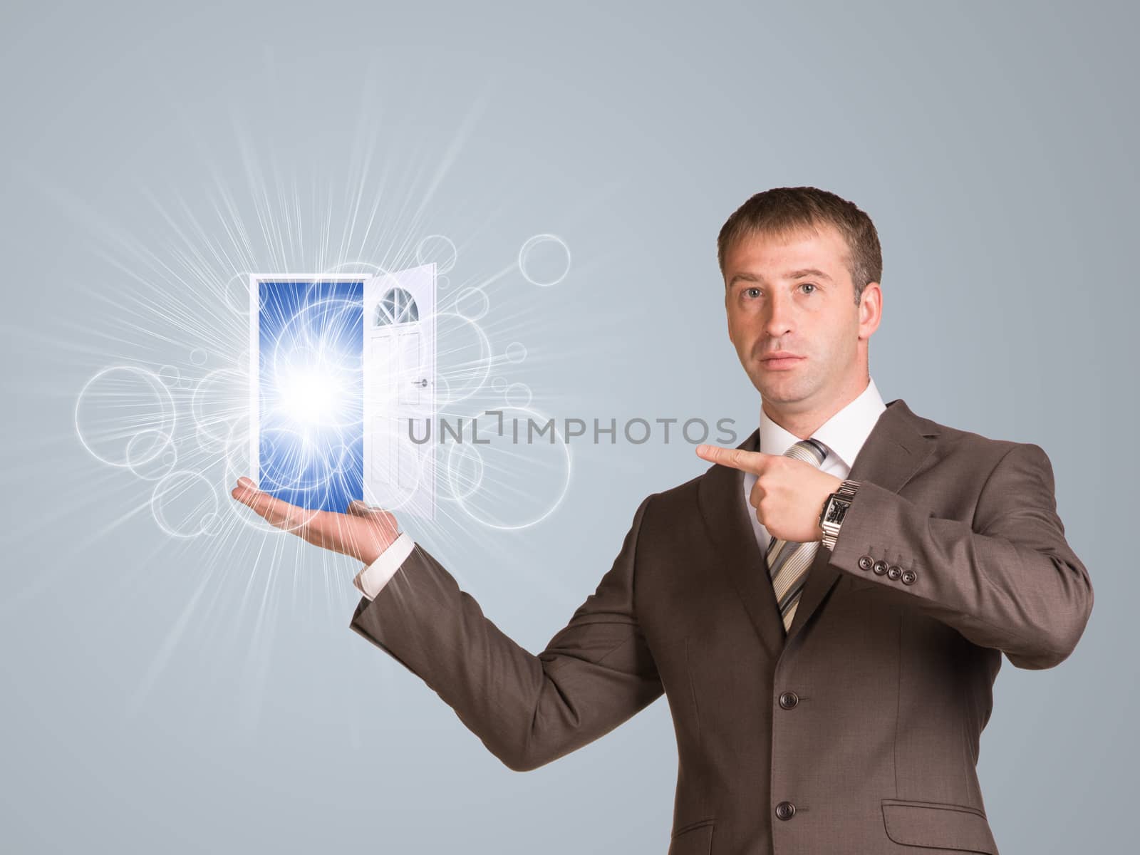 Business man hold open bright door in hand by cherezoff