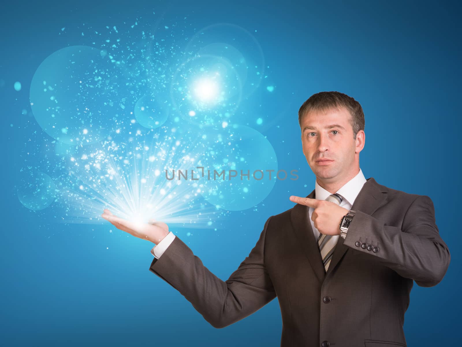 Business man hold magic light in hand by cherezoff