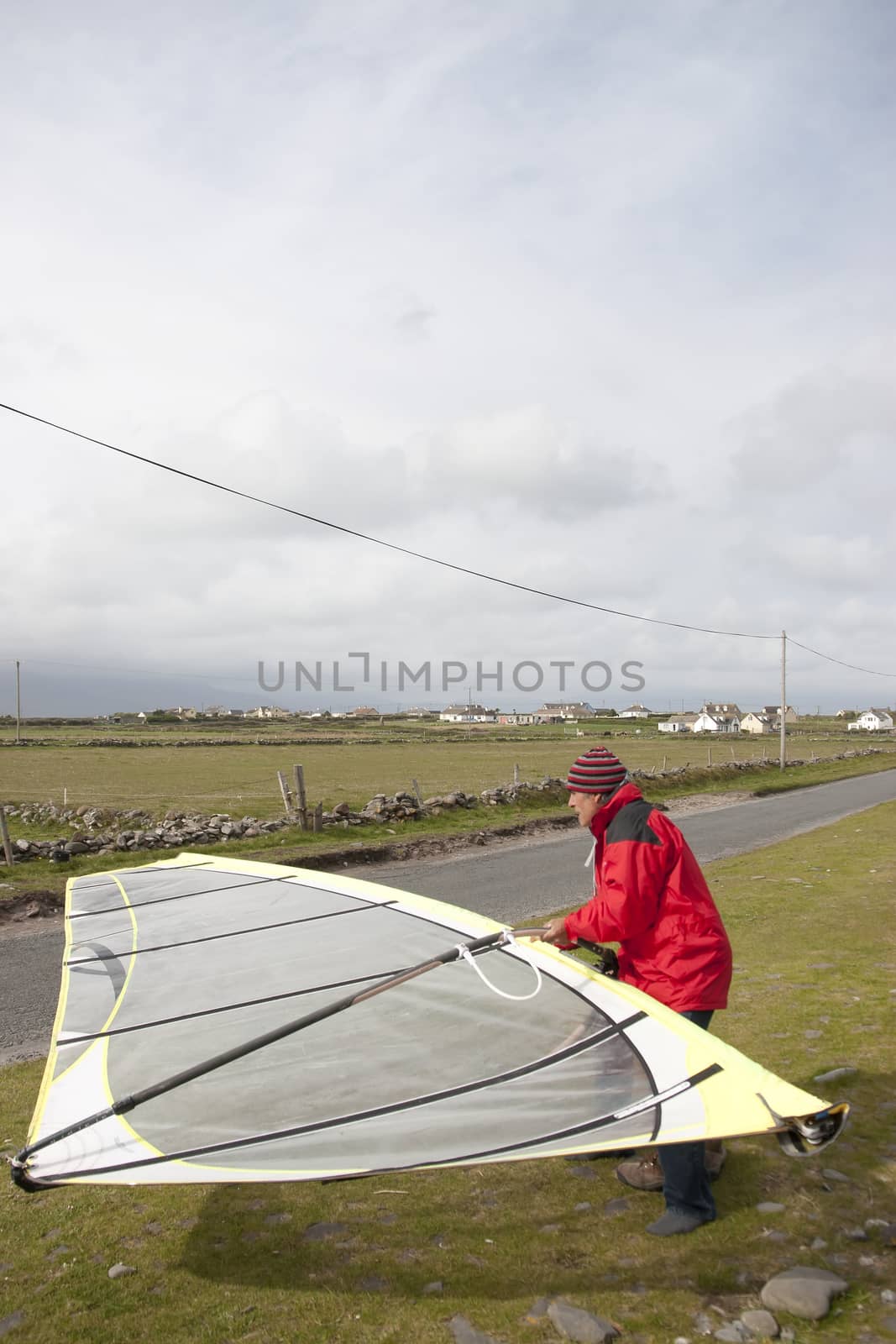 windsurfer getting equipment ready on the beach in the maharees county kerry ireland