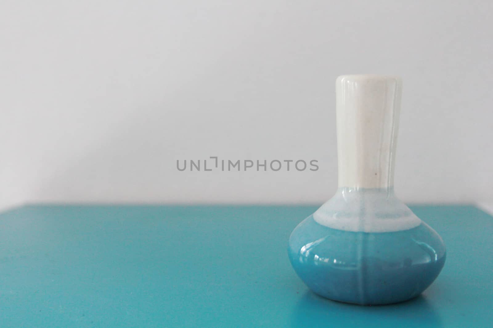 This is a white and blue ceramic vase on the table.
