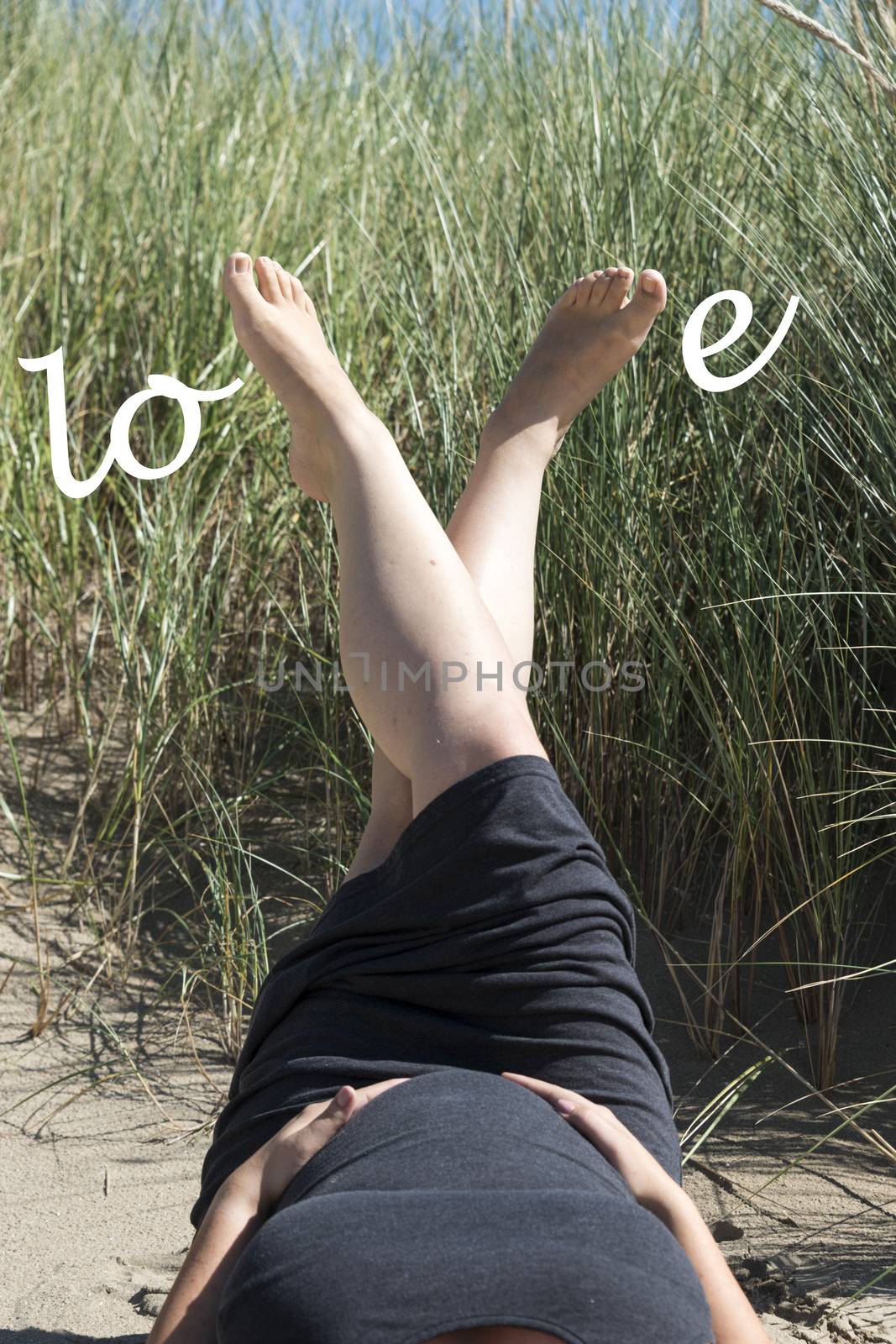 pregnant woman with love letters on her belly in the sand