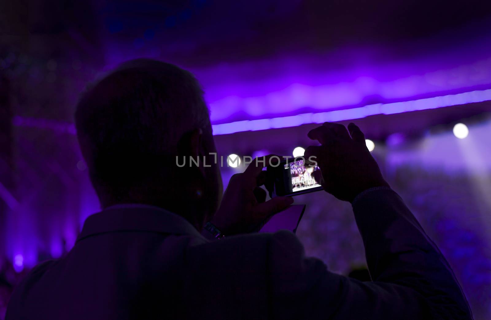 Man taking pictures with smartphone during a concert