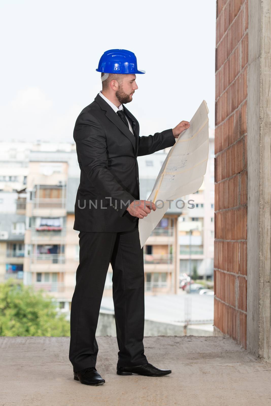 Caucasian Male Construction Manager With Blueprint by JalePhoto