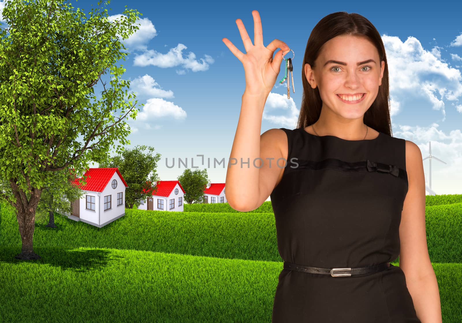 Woman showing key and houses with landscape as backdrop
